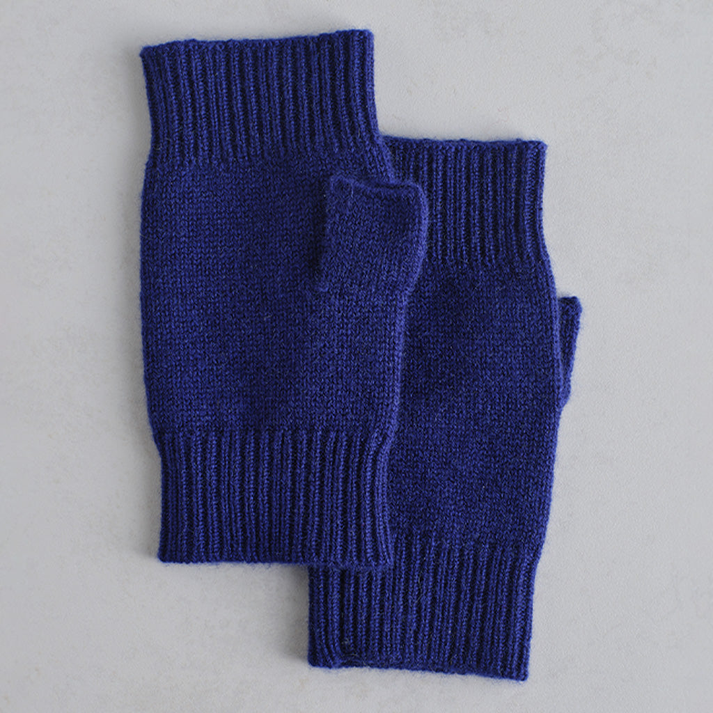 A pair of dark blue knit fingerless gloves or wrist warmers with ribbed cuffs, laid flat on a light gray background.