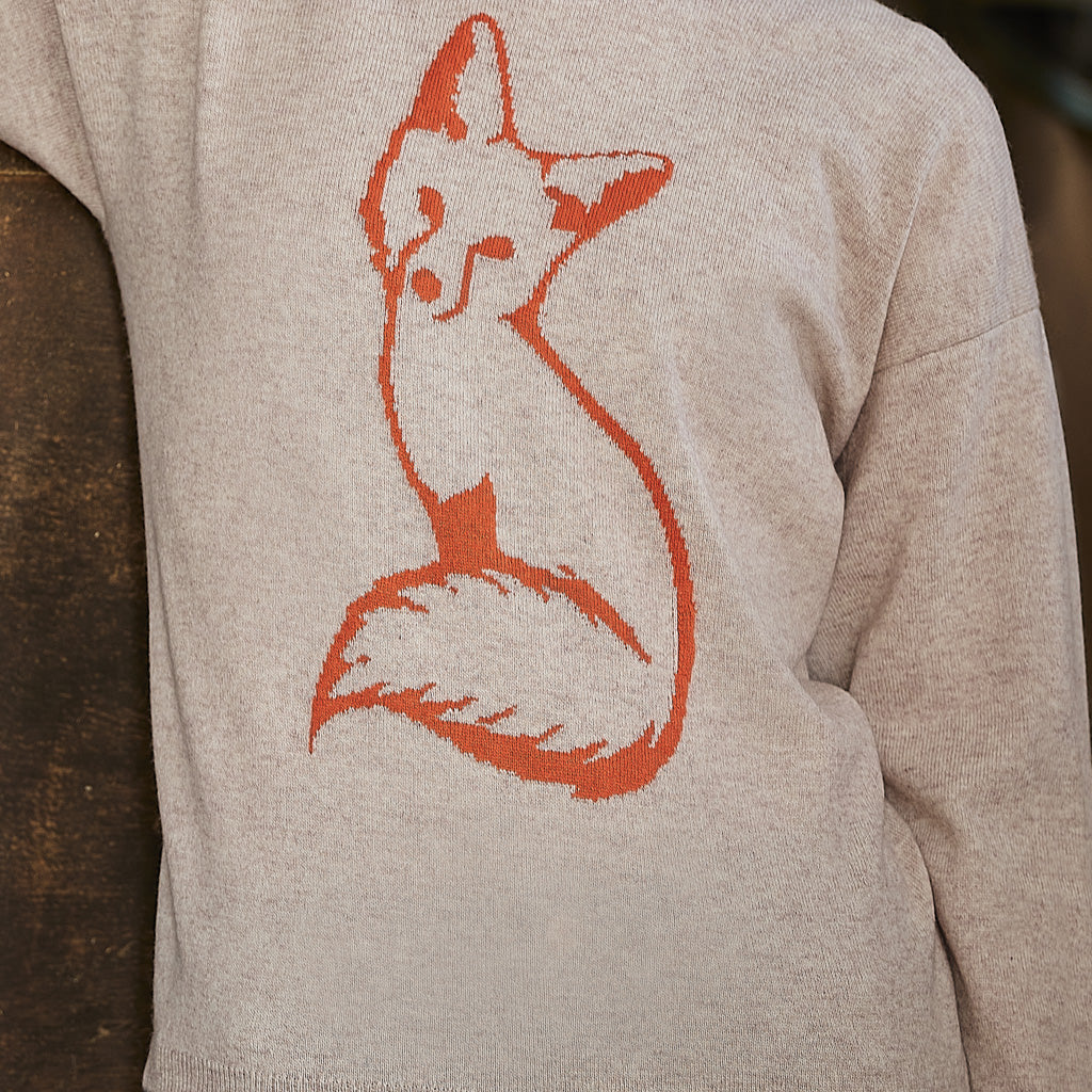 Close-up of a light heather gray sweatshirt featuring a stylized orange fox graphic on the front.