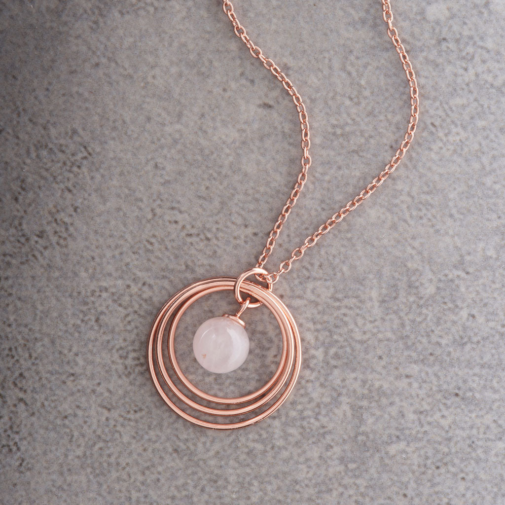 Gold Plated & Rose Quartz Triple Disc Necklace on a grey background