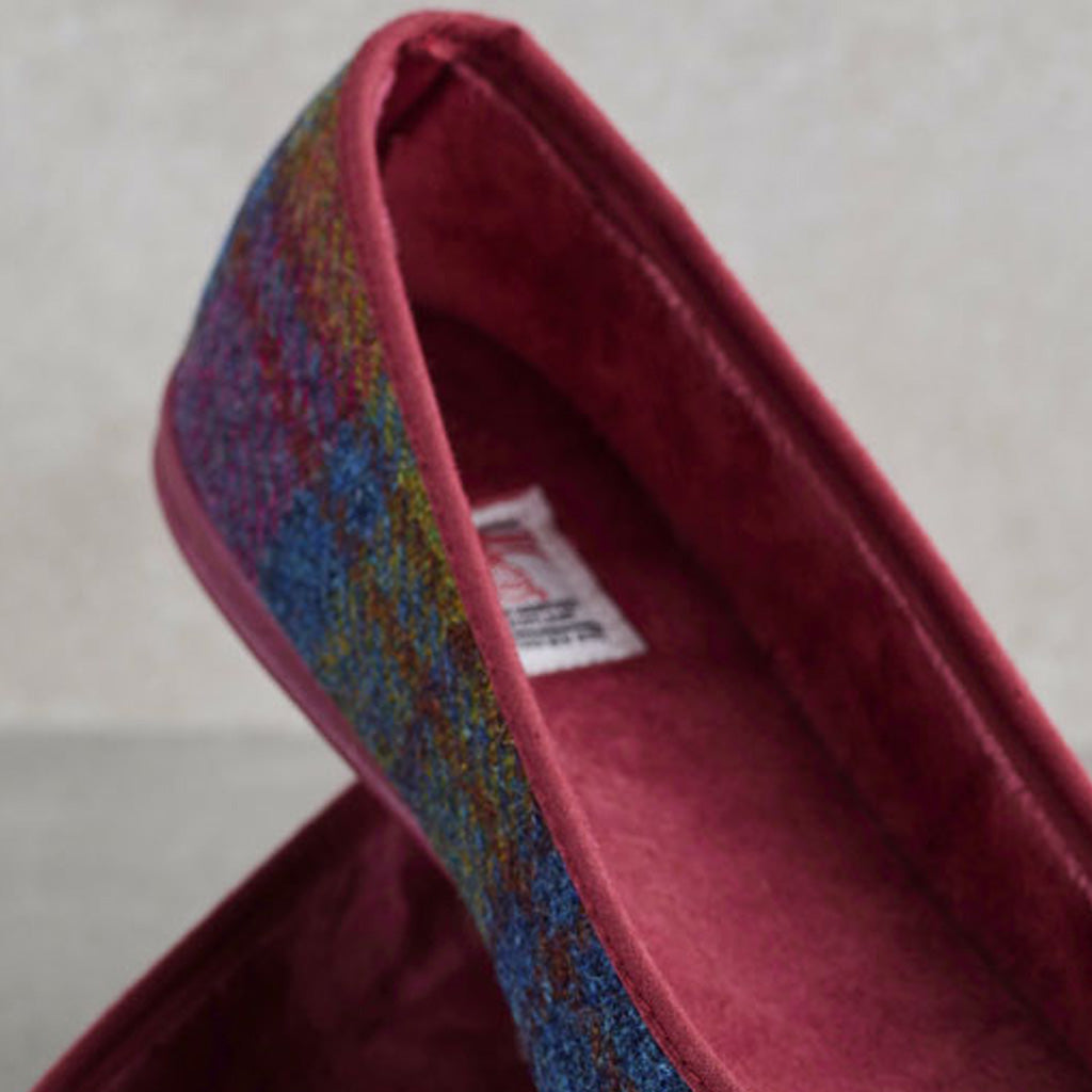 A close-up of a women's flat shoe showing the interior lining and side profile. The shoe has a textured multicolor tweed upper with blue, red, and yellow tones, and a deep burgundy velvet interior.