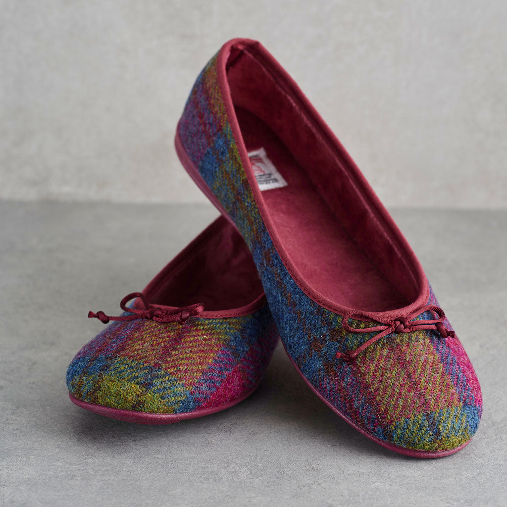 A pair of women's ballet flats with a multicolor plaid patterned upper and a deep burgundy velvet interior, displayed on a gray surface.