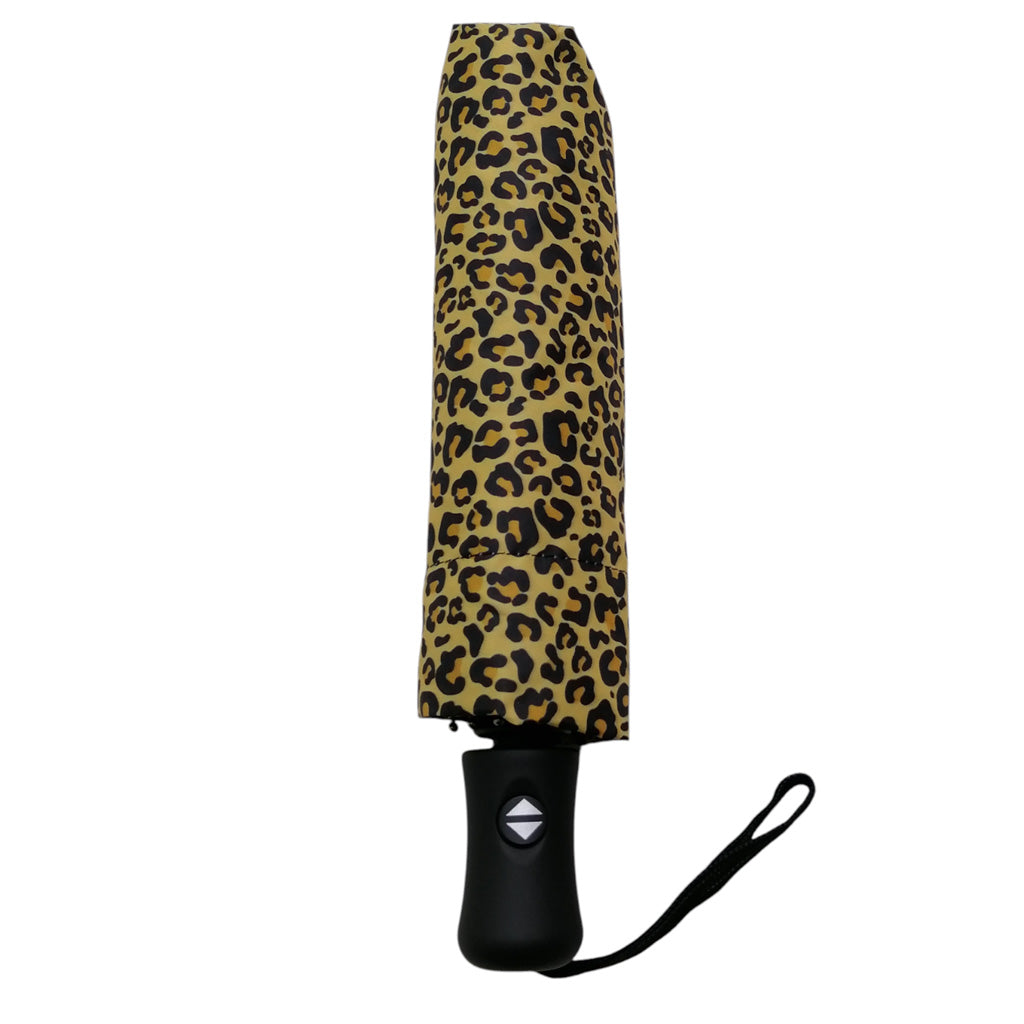 A closed compact umbrella with a tan and black leopard print pattern, featuring a black handle and wrist strap, shown against a plain white background.