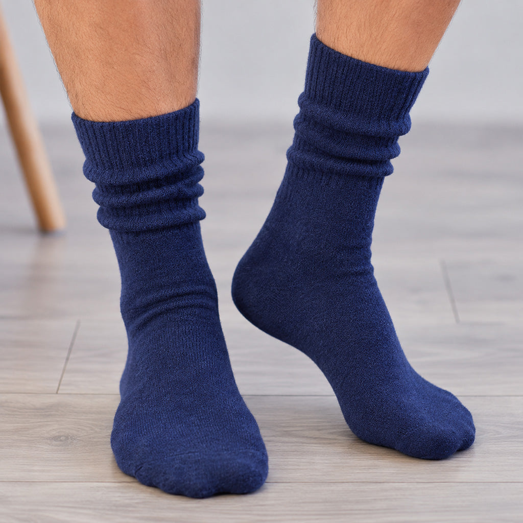 A close-up of a person's feet wearing dark navy blue crew socks, standing on a light gray wood-look floor.