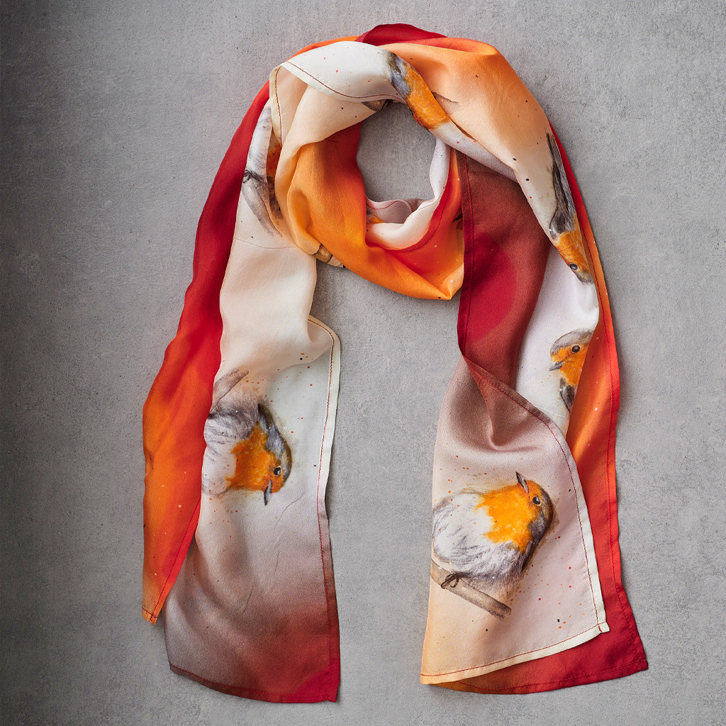 A lightweight rectangular scarf laid flat on a textured gray background, featuring a watercolor-style print of robin birds in orange, red, cream, and brown tones.