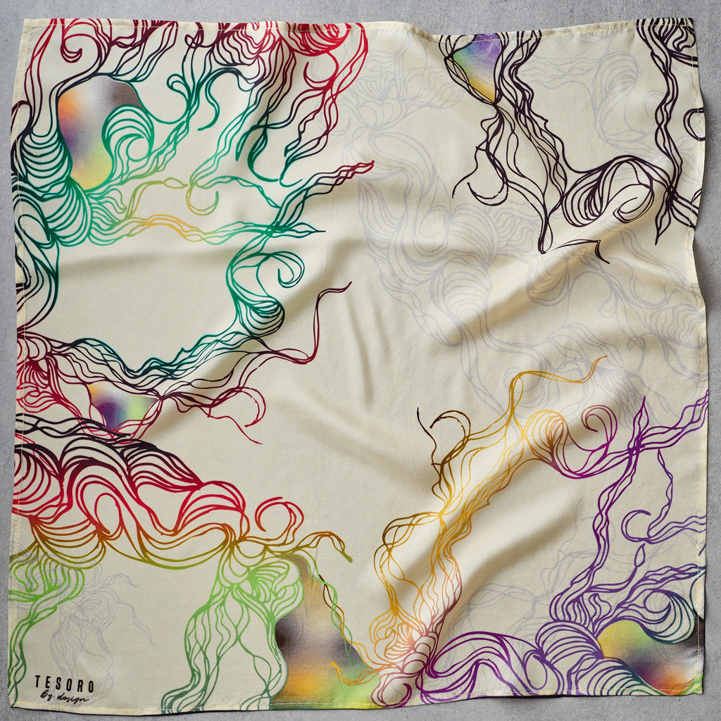 A square scarf laid flat on a gray surface, featuring an abstract wavy line pattern in multiple colors including red, green, blue, yellow, orange, and purple on a cream background. The brand name 'TESORO by design' is printed in the bottom left corner.