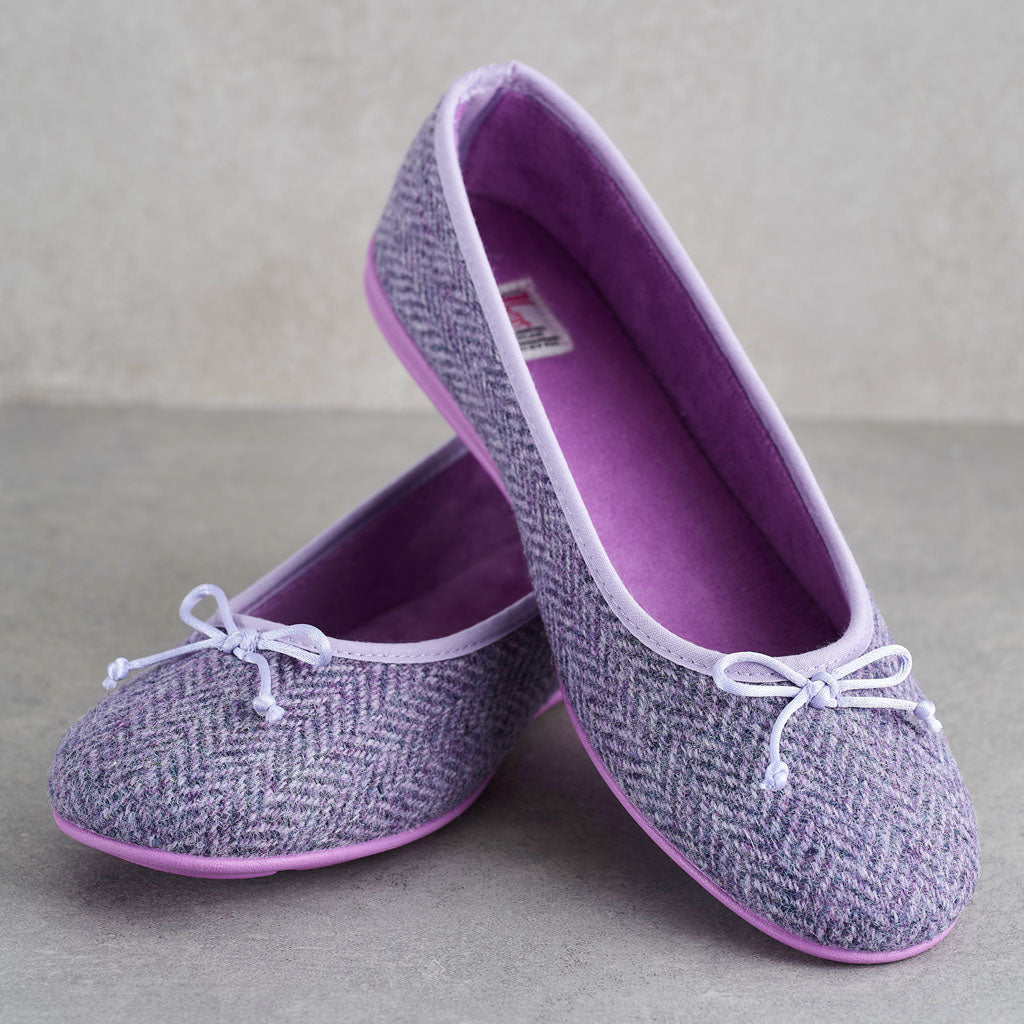 A pair of women's flat shoes with a lavender and gray herringbone pattern, featuring a white bow on the toe and a purple interior and sole.