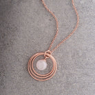 Gold Plated & Rose Quartz Triple Disc Necklace on a grey background