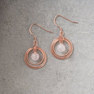 Rose Gold Plated & Rose Quartz Triple Disc Earrings on grey background.