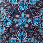 A square scarf with a symmetrical mandala pattern in shades of blue, black, and white, featuring paisley and star details.