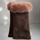 A pair of dark brown suede gloves with thick brown fur cuffs,
