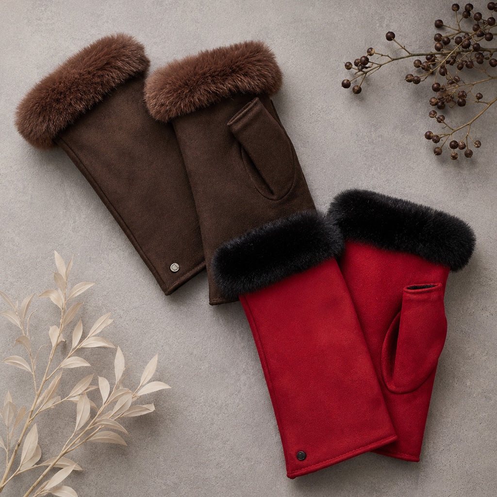 A pair of dark brown suede gloves with thick brown fur cuffs, and pair of red suede gloves with thick black fur cuffs, laid flat on a textured gray background.